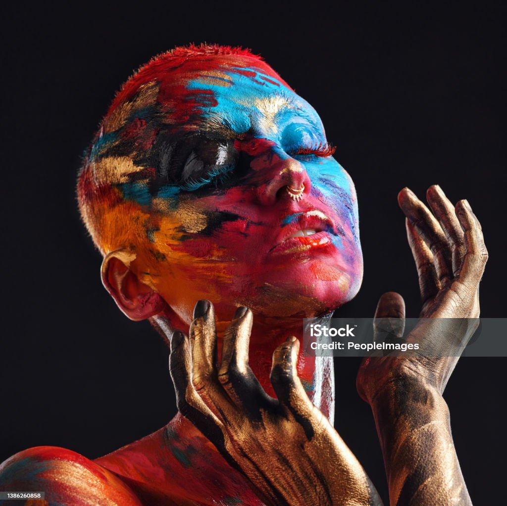 Shot of an attractive young woman posing alone in the studio with paint on her face My chaos is beautiful Art Stock Photo