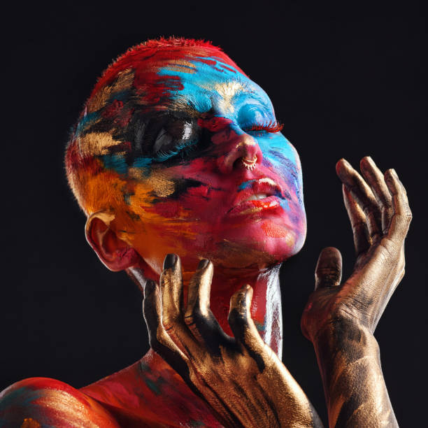 shot of an attractive young woman posing alone in the studio with paint on her face - visual art fotos imagens e fotografias de stock