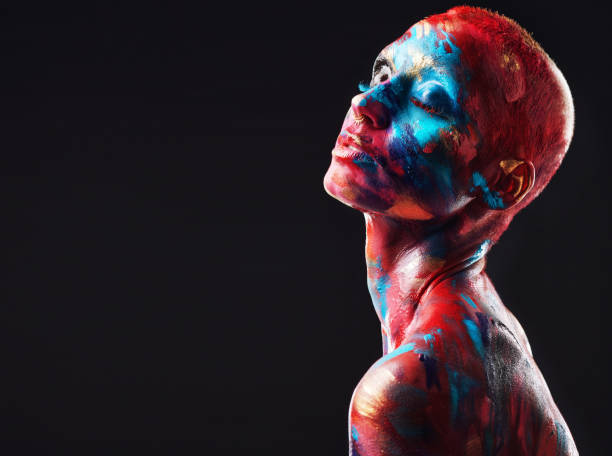 shot of an attractive young woman posing alone in the studio with paint on her face and body - beautiful confidence bizarre exoticism imagens e fotografias de stock