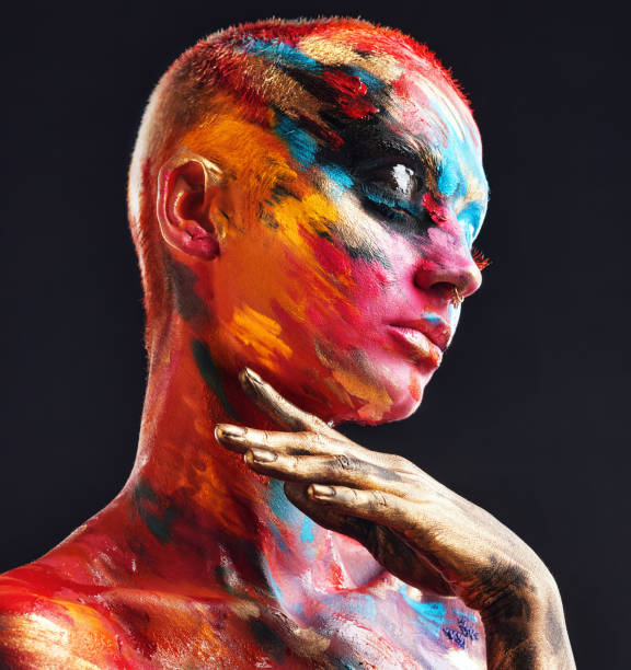 shot of an attractive young woman posing alone in the studio with paint on her face and body - beautiful confidence bizarre exoticism imagens e fotografias de stock