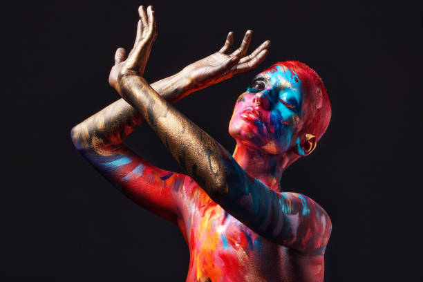 shot of an attractive young woman posing alone in the studio with paint on her face and body - beautiful confidence bizarre exoticism imagens e fotografias de stock