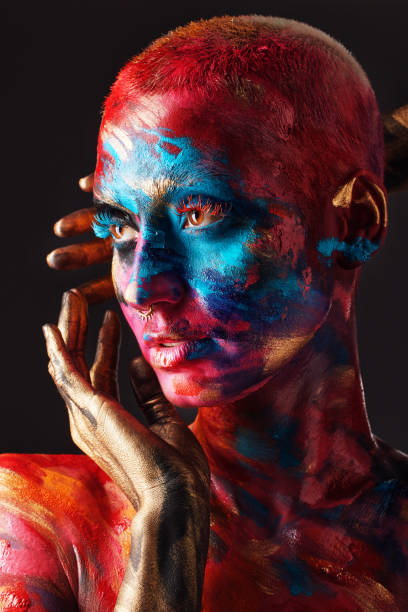 shot of an attractive young woman posing alone in the studio with paint on her face and body - beautiful confidence bizarre exoticism imagens e fotografias de stock