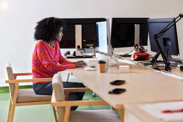istock A young woman works on a computer in a small office. 1386263348