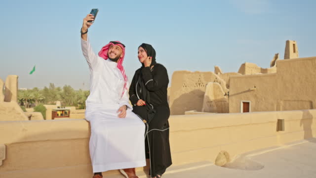 Middle Eastern couple taking selfie at Diriyah ruins