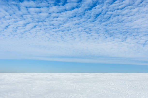 istock background spring landscape. white snowy field and blue sky with clouds 1386271836