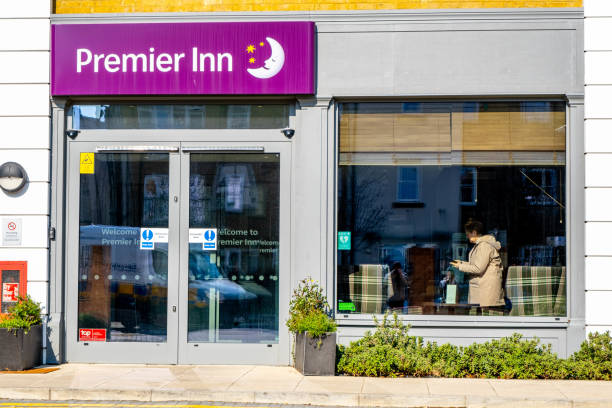 Entrance Of Modern Premier Inn Hotel Epsom Surrey London UK, March 8 2022, Entrance Of Modern Premier Inn Hotel With Customer Standing In The window surrey hotel southeast england england stock pictures, royalty-free photos & images