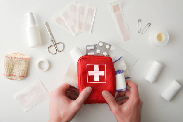 istock Hands picking up travel first aid bag on white table 1386276483