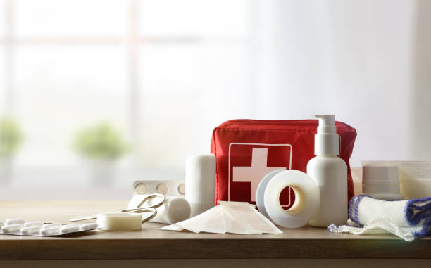 Basic home kit for cures in domestic accidents on table Basic home kit for cures in domestic accidents on a wooden table in a room. Horizontal composition. Front view. first aid kit stock pictures, royalty-free photos & images