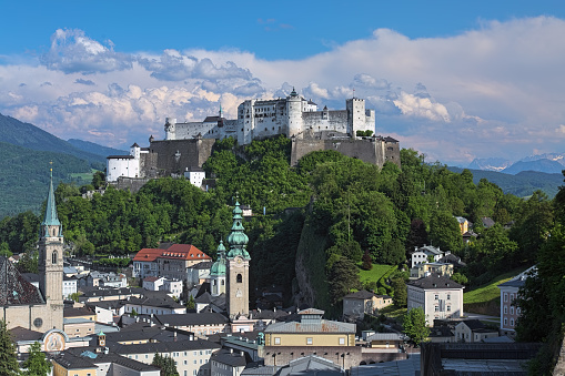 Salzburg, Austria - May 22, 2017: Hohensalzburg fortress on top of Festungsberg mountain, and church towers of Salzburg Old Town. View from observation point at Monchsberg mountain.