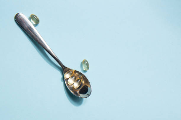 istock Vitamin tablets in an iron spoon on a blue background. Complementary and medical products 1386276764
