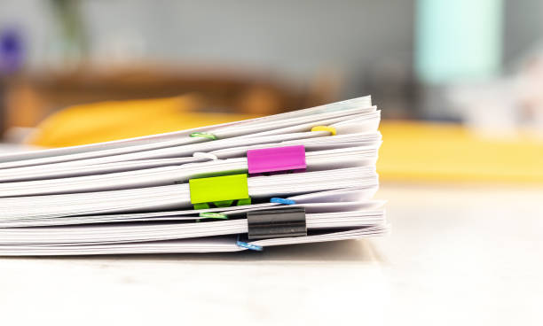 Reserch and report paper, documents concept Pile of paperwork with colorful paper clips on office desk, blurred background. Administration of company's report information, organized job at workplace. Student research sheet stack on table. paper clip office supply stack heap stock pictures, royalty-free photos & images