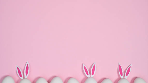 istock Creative Easter copy space background with eggs with bunny ears on pastel pink theme. Flat lay 1386276791