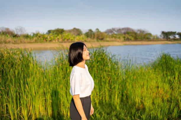 istock Asian woman looking into the distance by the beautiful lake 1386278607
