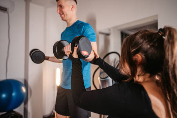 istock Man doing his workout with help of his fitness instructor 1386279801