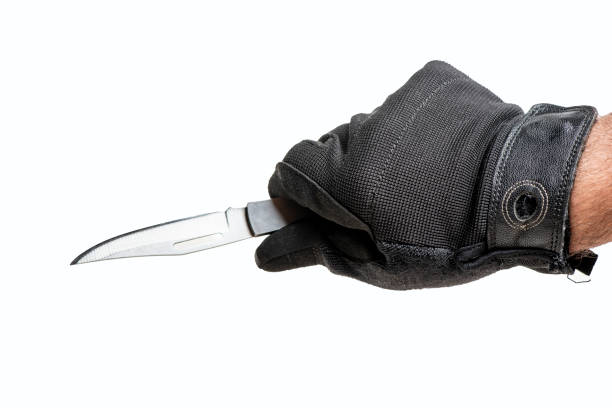 istock Man hands in gloves holding  the knife. 1386285303