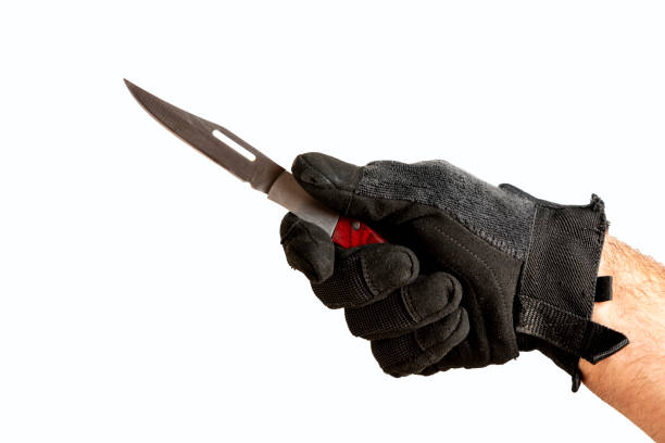 istock Man hands in gloves holding  the knife. 1386285304