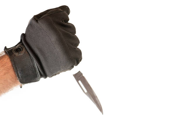 istock Man hands in gloves holding  the knife. 1386285311