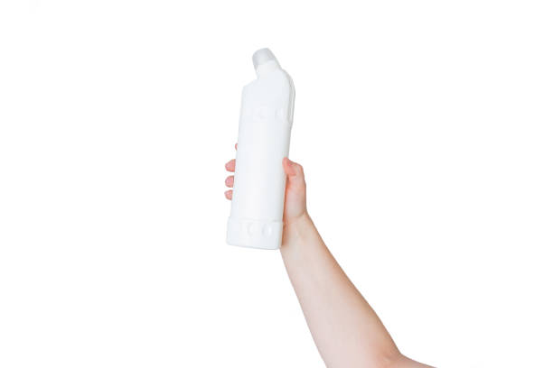 istock hand holding a plastic bottle of cleaning agent bleach  on a white background, isolated 1386287652