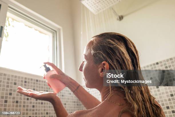 Woman Takes Shower And Uses Pink Conditioner Stock Photo - Download Image Now - Hair Conditioner, Shampoo, Bottle