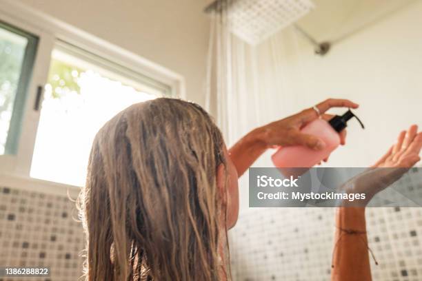 Woman Takes Shower And Uses Pink Conditioner Stock Photo - Download Image Now - Shampoo, Shower, Women