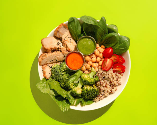 istock Poke bowl with chicken, quinoa, broccoli, chickpeas, tomato and spinach. Top view. 1386289607