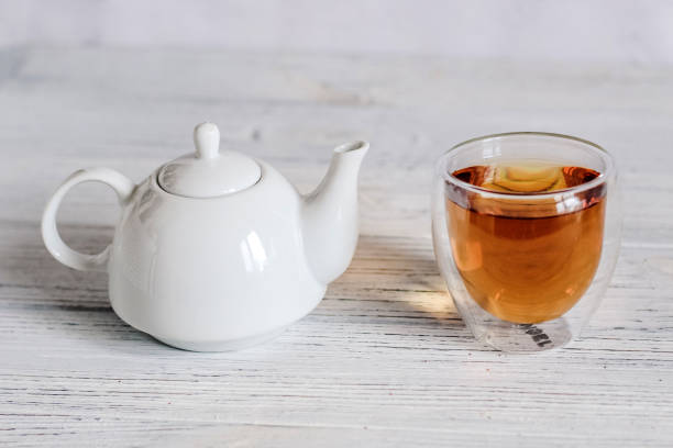 istock White decorative teapot with a glass of tea 1386289749