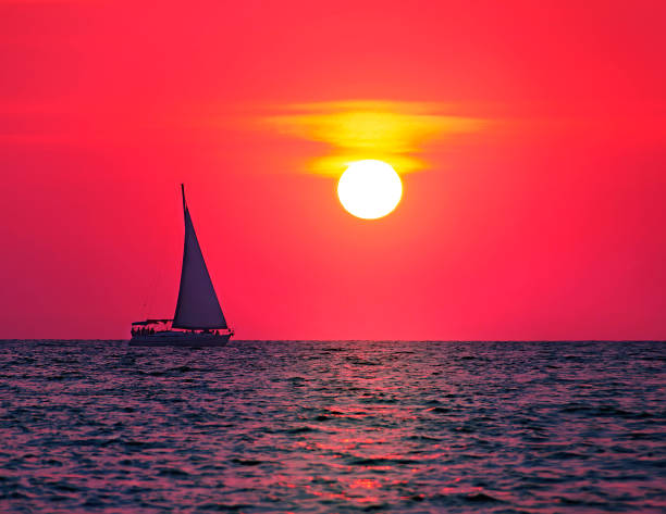 istock sea yacht sails against the backdrop of the setting sun 1386291394