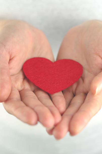 istock Red heart in female palms on a white background, close-up 1386291573