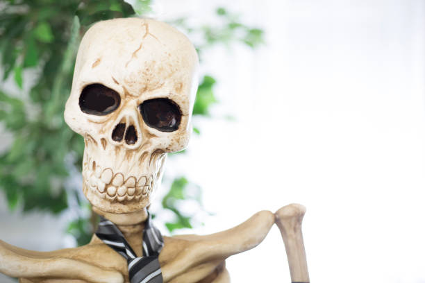 Skeleton testing his blood pressure at home.  This is a close up head and shoulders shot of the Skeleton at his desk at home.