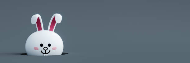 istock White Easter bunny peeking from ground hole on gray background 1386294475