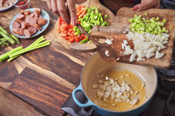 preparando cajun style chicken, camarão e salsicha jambalaya em um pote de ferro fundido - comida do sul - fotografias e filmes do acervo