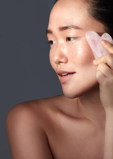 istock Studio shot of a beautiful young woman using a scraping tool on her face 1386298418
