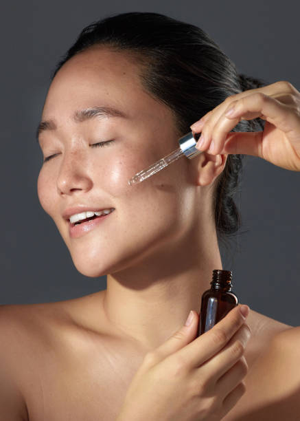 istock Studio shot of a beautiful young woman using a face serum 1386298424