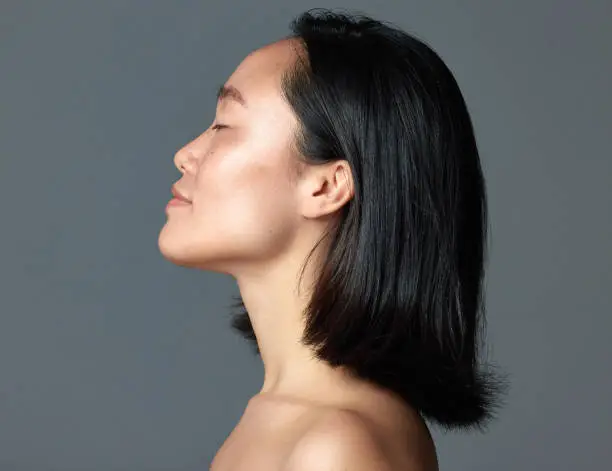 Photo of Studio shot of a beautiful young woman posing against a grey background