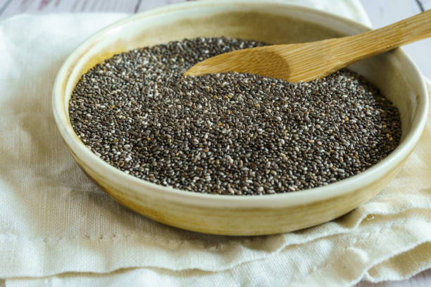 istock Bowl with chia seeds and wooden spoon. Rustic wooden table 1386302520