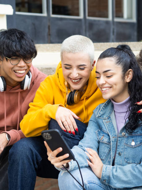 istock Group of young students looking at smart phone smiling 1386310625