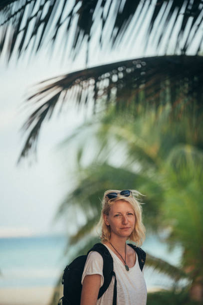 A woman surrounded by palm trees