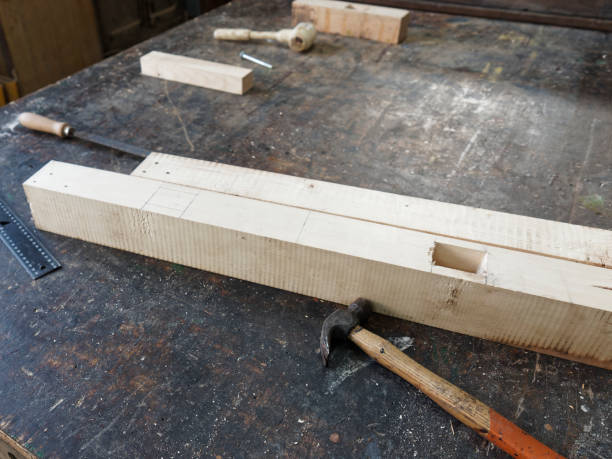 istock Oak wooden bar blocks materials stacked at carpentry woodwork workshop with tools and sawdust on background. 1386315341