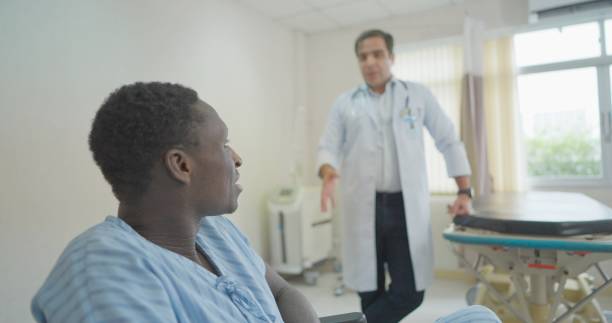 istock Specialized doctors explain about symptoms after treatment to patient is sitting on in a wheelchair and moving into recovery room. Caring from medical professional. Concept of hospital, health care. 1386333295