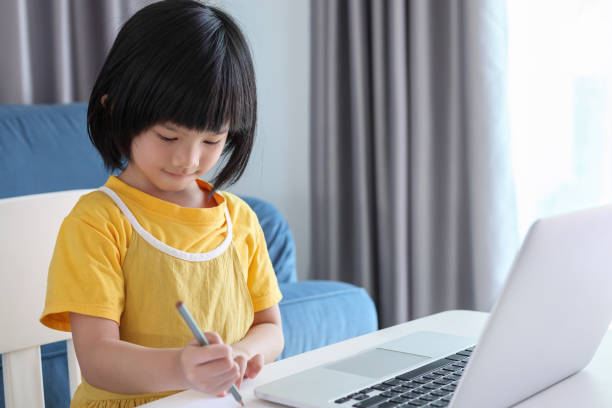 istock little asian girl student study online using laptop computer at home 1386334256