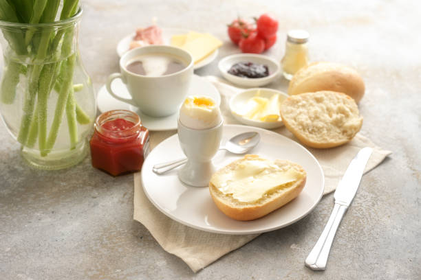 istock Continental breakfast sweet and salty with buns, cooked egg and a cup of coffee on rustic stone, copy space, selected focus 1386334317