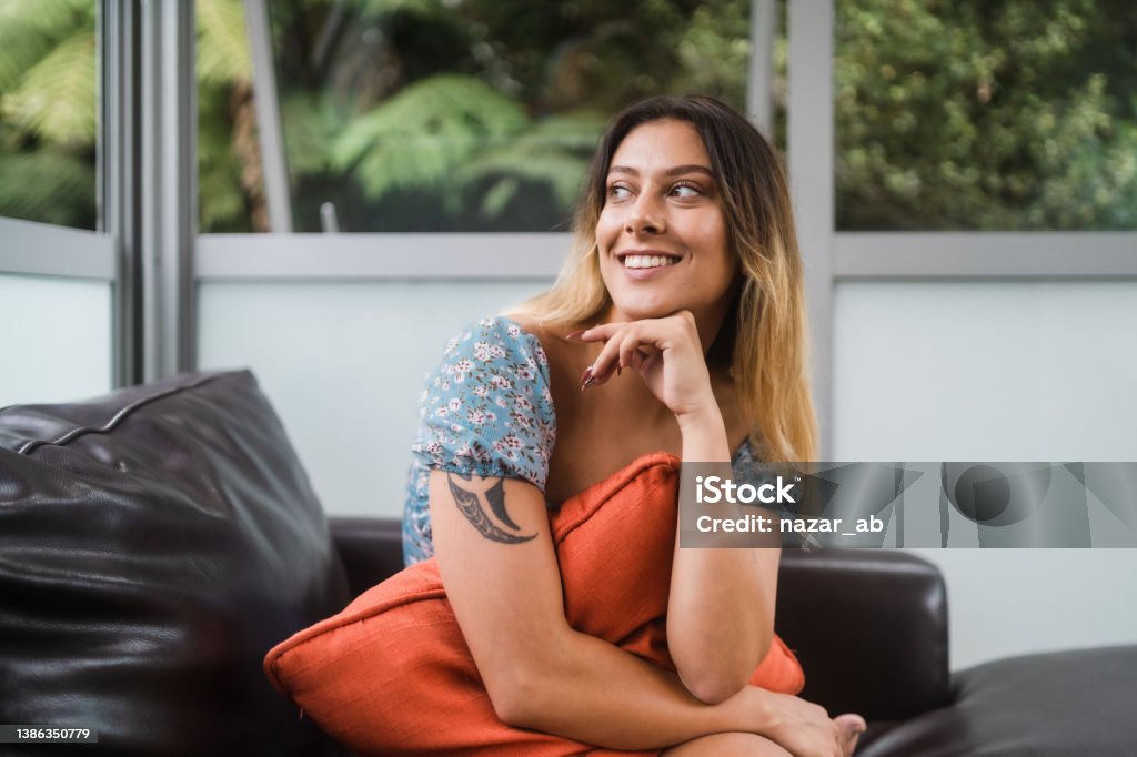 Relaxing at home. The shot of a Maori woman with a big smile on her face. Māori People Stock Photo