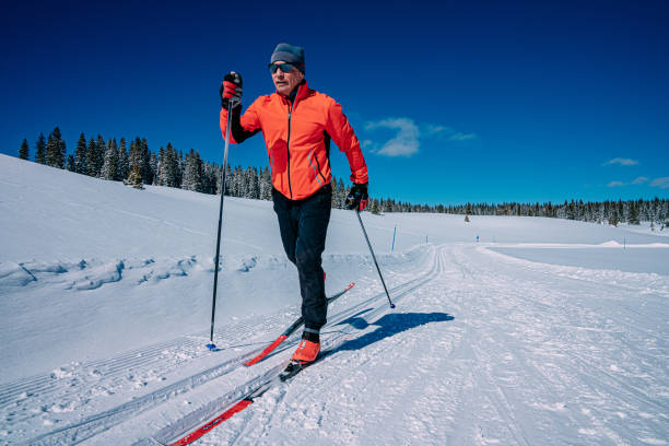 Close-Up Low Wide Angle Shot of a Cross-Country Skier Skiing in a Diagonal Stride Along a Groomed Trail on a Clear, Sunny "Blue Bird" Day in the Grand Mesa National Forest in Colorado stock photo