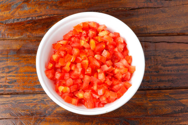 istock Raw chopped and diced tomatoes cubes in ceramic bowl over rustic wooden table 1386358001