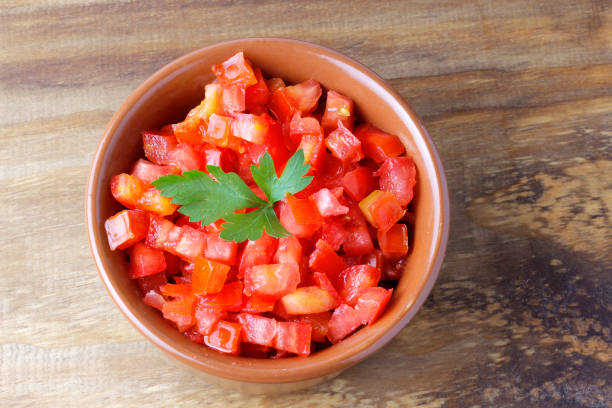 istock Raw chopped and diced tomatoes cubes in ceramic bowl over rustic wooden table 1386358004