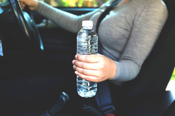 Drinking water in the car prepared for traveling stock photo