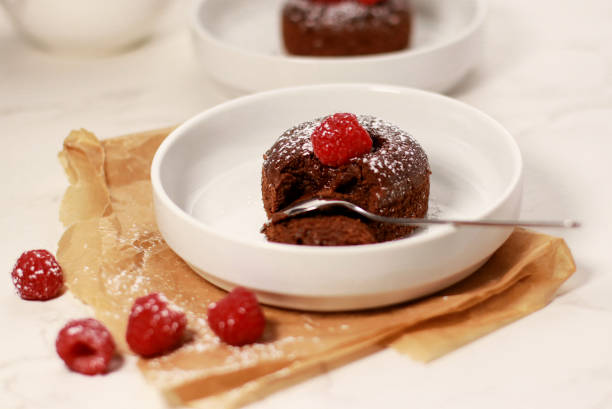 istock Close up of chocolate lave cake on a white plate with raspberries, white marble table 1386370831