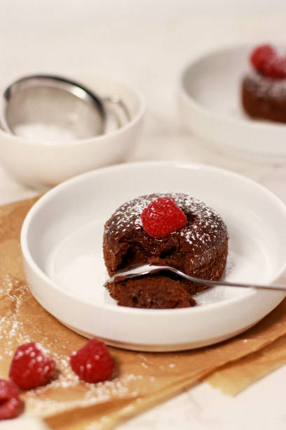 istock Close up of chocolate lave cake on a white plate with raspberries, white marble table 1386370834