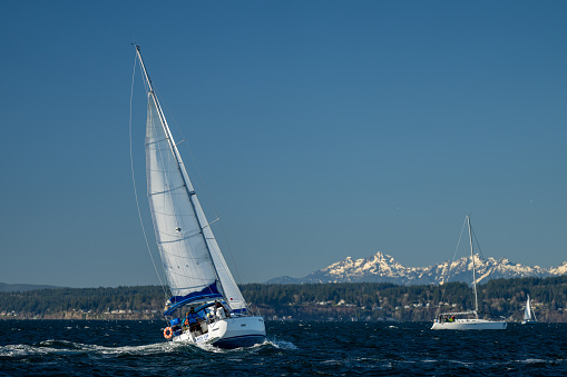 Seattle, Washington, USA - February 12, 2022: The winter Snowbird Regatta hosted by the The Shilshole Bay Yacht Club in Seattle, Washington races on a clear winter day.
