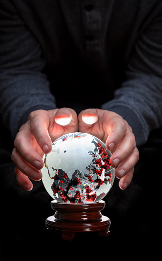 Covid-19, in crystal ball earth globe with hands predicting future over Asian continent, China, Russia